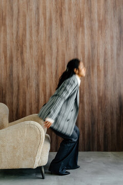 Businesswoman Rising from Armchair in Modern Office Interior