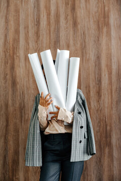 Businesswoman Holding Rolled Architectural Plans in Office