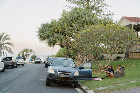UGC Two surfers relaxing by car with boards after surf in parking lot