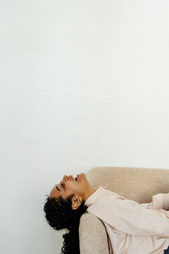 Laughing Businesswoman Relaxing in Armchair During Break