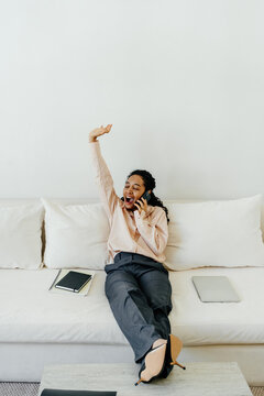 Tired Remote Worker Yawning During  Phone Call Relaxing on Sofa