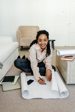 Designer Working on Large-Scale Project Drawings in Home Office