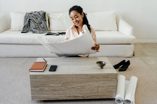 Designer Reviewing Large Architectural Drawings in Home Office 