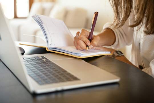 Crop of anonymous woman using laptop at office