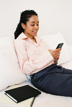 Businesswoman Using Smartphone While Relaxing on Sofa