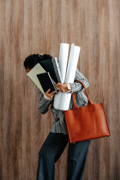 Businesswoman Carrying Documents and Blueprints in Office Attire