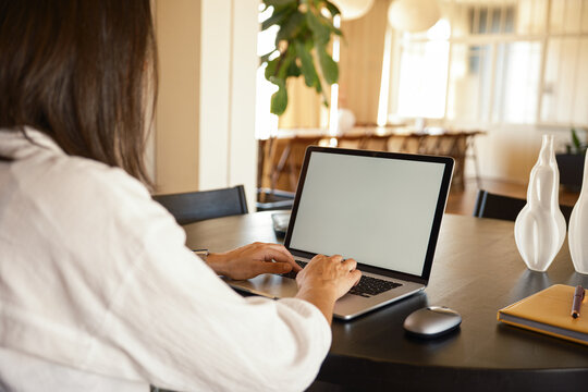 Crop of anonymous woman using laptop at office