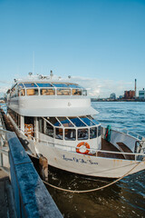 Fototapeta premium New York, USA, 22 April 2026: Louisa Of The Seas boat docked at New York harbor. White passenger vessel Louisa Of The Seas moored at a pier in New York City with East River background.