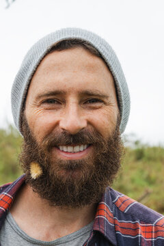 Adventurer with beard wearing beanie smiling outdoors