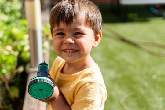 Boy Showing Hose Nozzle Smiling