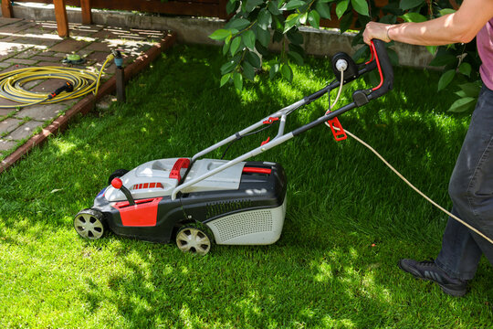 A man mows the lawn in the yard.