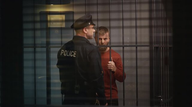 Nervous male inmate offering money to a corrupt police officer, bribery concept