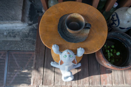 Climbing cat on table with coffee cup at cafe in Yanaka Ginza, Tokyo