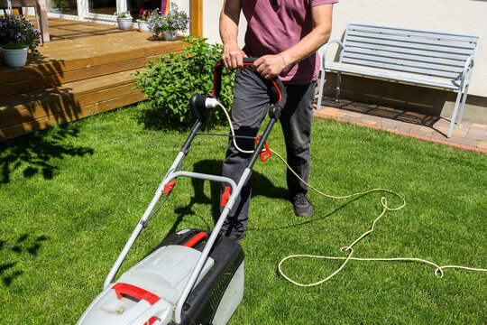 A man mows the lawn in the yard.