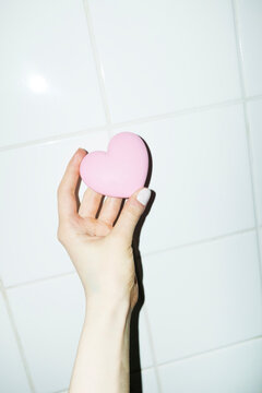 Hand holding cute pink heart shaped love pocket make up mirror