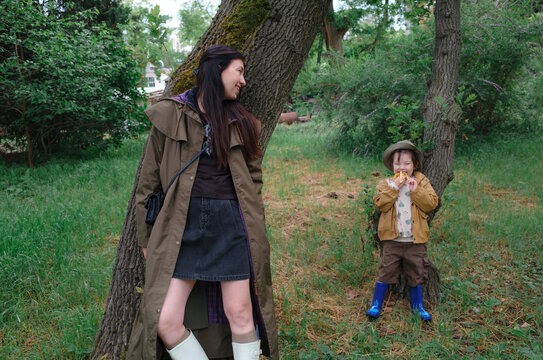 Mother and son standing by trees in a botanical garden
