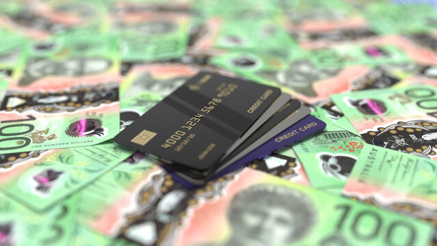 Black credit cards placed on top of australian dollar banknotes.