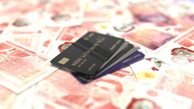Black credit cards resting on british pound sterling banknotes.
