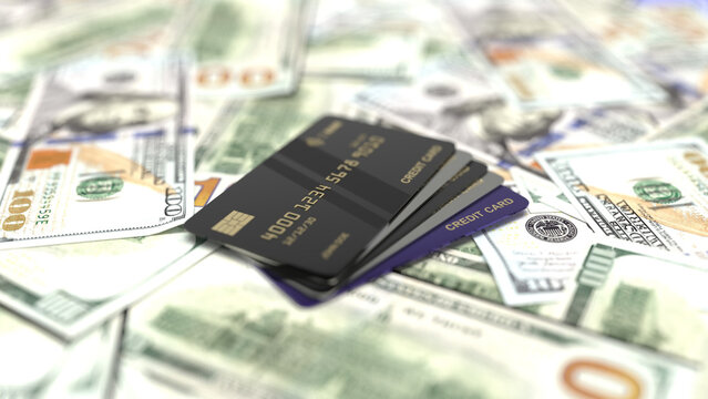 Black credit cards on a pile of us dollar banknotes.
