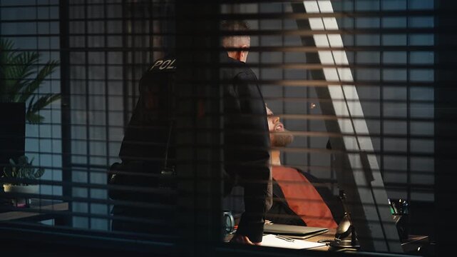 Smiling arrested man joking with a police officer during interrogation