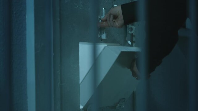 Prison guard performing a routine inspection through the hatch of a cell door