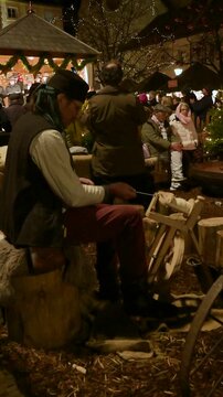 Artisan Spinning Wool with Traditional Wooden Tool at Christmas Fair &ndash; Vertical
