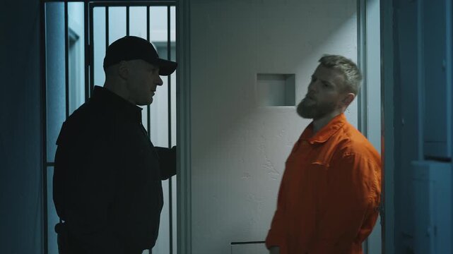 Prison guard escorting a handcuffed male inmate to the visitation room