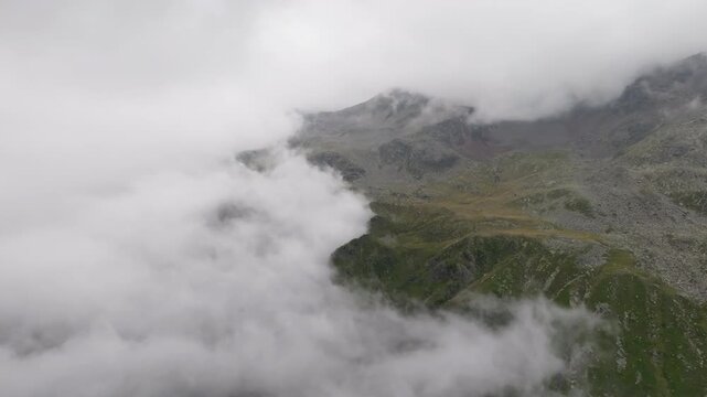 Aerial view of Timmelsjoch mountain pass on the border of Austria and Italy with dramatic Alpine peaks covered by clouds breathtaking Tyrol landscapes scenic travel destination and untouched nature