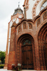 Obraz premium Ornate brick entrance portal with carved decorative details at the historic synagogue. Fine craftsmanship highlighting the Art Nouveau architecture of Subotica, Serbia.
