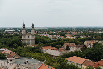 Obraz premium Elevated panoramic view over the historic center of Subotica, Serbia, with colorful rooftops and church towers. A broad urban landscape showcasing the city's distinctive architecture.
