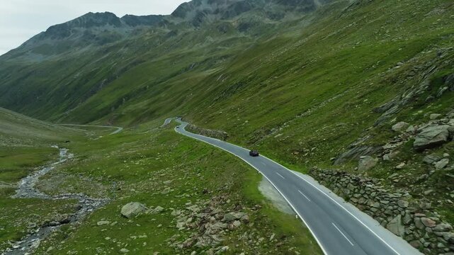 Aerial view of a car driving along the Timmelsjoch High Alpine Road in Austria surrounded by spectacular mountain scenery scenic routes and travel across Europe