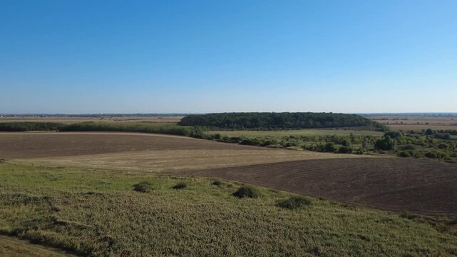 Panoramic Drone Shot Over Summer Farmland. Stunning Drone Aerial of Cultivated Fields and Green Vegetation.