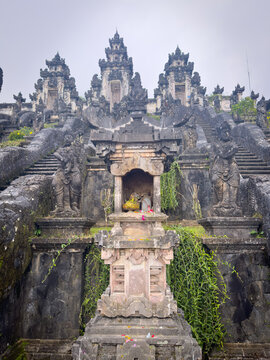 Weathered stone shrine and candi bentar split gates on the temple terraces at Pura Lempuyang, Karangasem, East Bali, Indonesia.