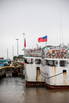 Ship docked at Apia's harbor with flags flying, Samoa