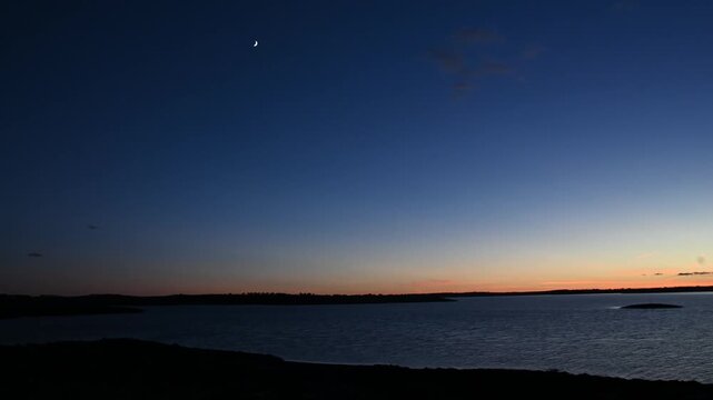Scenic reservoir at sunset with calm water and mountains in the background under warm evening light and peaceful atmosphere blue