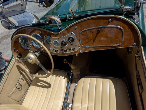 TAVERNES BLANQUES, SPAIN - JUNE 14, 2026.Classic MG TF roadster interior with wooden dashboard, vintage steering wheel, and beige leather upholstery on display
