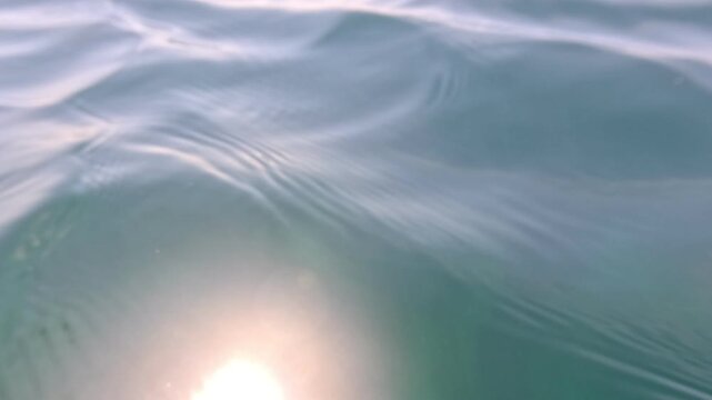 Water ripples ocean gentle turquoise waves undulating on the surface of the calm sea during daylight creating a serene tranquil atmosphere