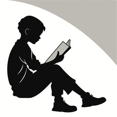 Silhouette of a young boy sitting and reading a book