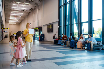 Group stands at a busy airport terminal waiting for arrival of family members or friends © Marko