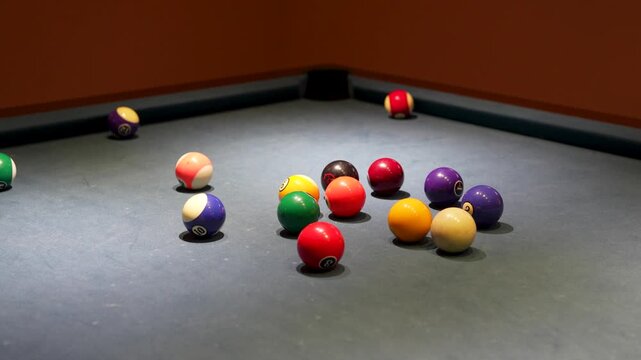 Billiard table break shot scattering colorful pool balls close up.