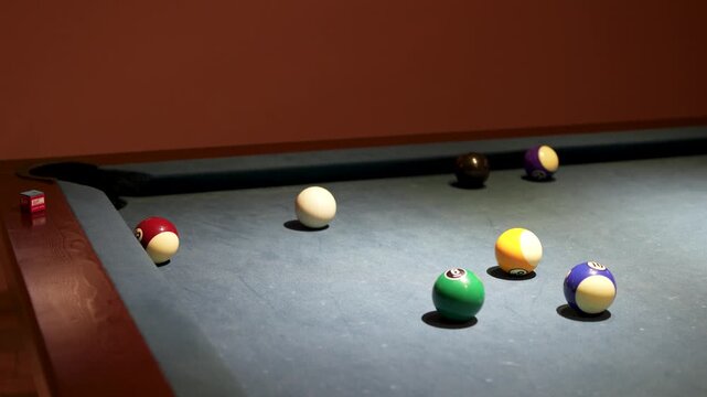 Billiard player in glove aiming cue at white cue ball close up.