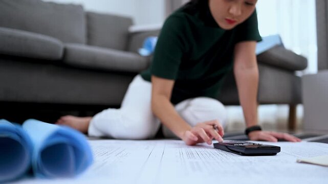 Calculator on blueprint with architect planning in background