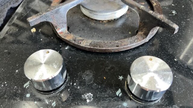 A dirty gas stove with greasy burners in a home kitchen before cleaning, household chores, sanitation, kitchen maintenance, domestic life.