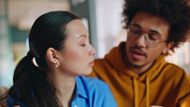 Close up multiracial couple talking serious problem home. Boyfriend comforts