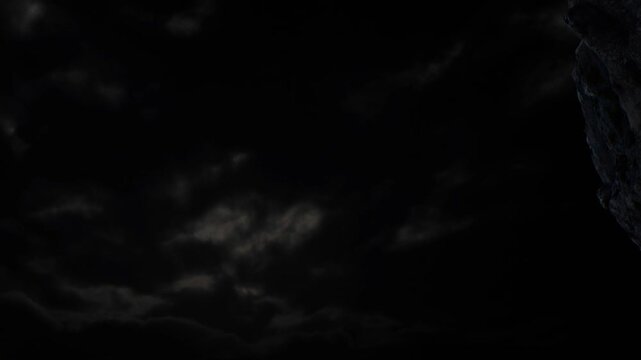 Clouds gather in the sky at night, blocking light and creating a dark atmosphere. The scene shows a remote location with no visible light sources.