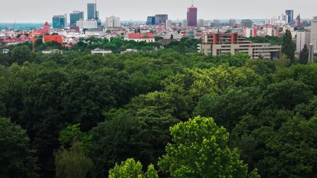 City Skyline Modern Residential Buildings Green Park Forest Horizon. A high angle drone shot capturing contemporary residential real estate apartments