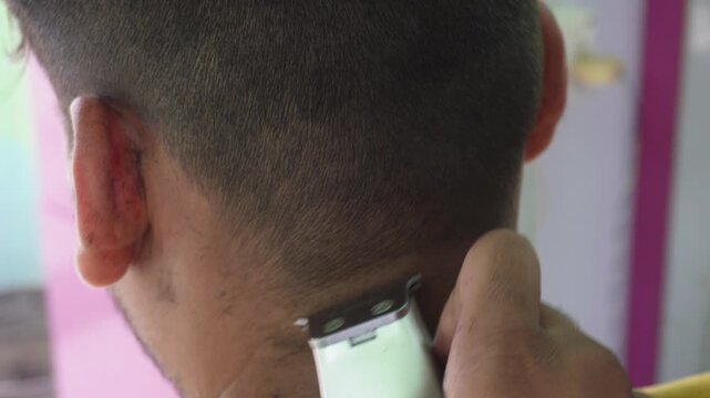 Barber trimming neck hairline with precise professional care