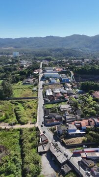 Panorama a&eacute;reo do bairro Botujuru, em Mogi das Cruzes, destacando resid&ecirc;ncias, galp&otilde;es, ruas, vegeta&ccedil;&atilde;o e relevo natural na regi&atilde;o do Alto Tiet&ecirc; paulista.