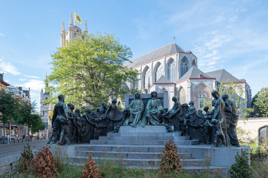 Ghent, Belgium - September 15, 2022: Van Eyck Brothers Monument, backdrop of the Cathedral of Saint Bavo. The sculpture is honors the brothers who painted the Adoration of the Lamb in the cathedral.