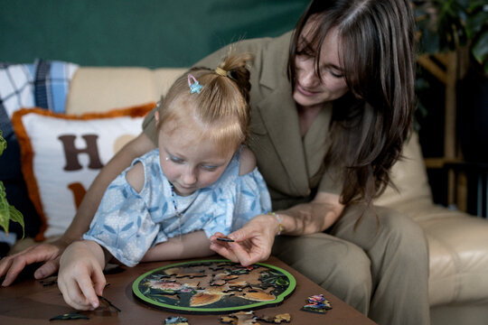 Mother and child focus on assembling a colorful puzzle